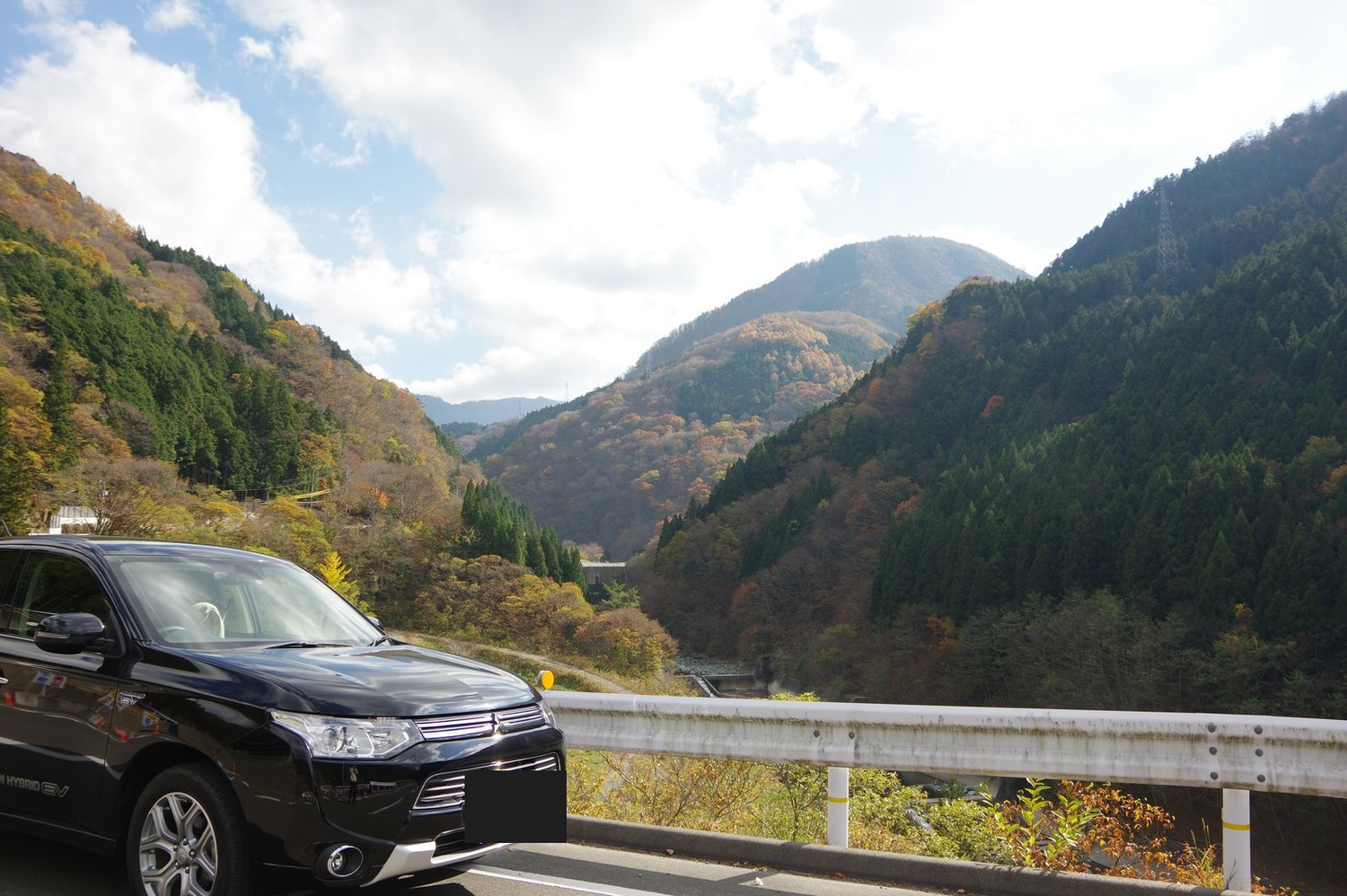 紅葉の渓谷に停めた黒いアウトランダーPHEV。2014年11月、四国の祖谷