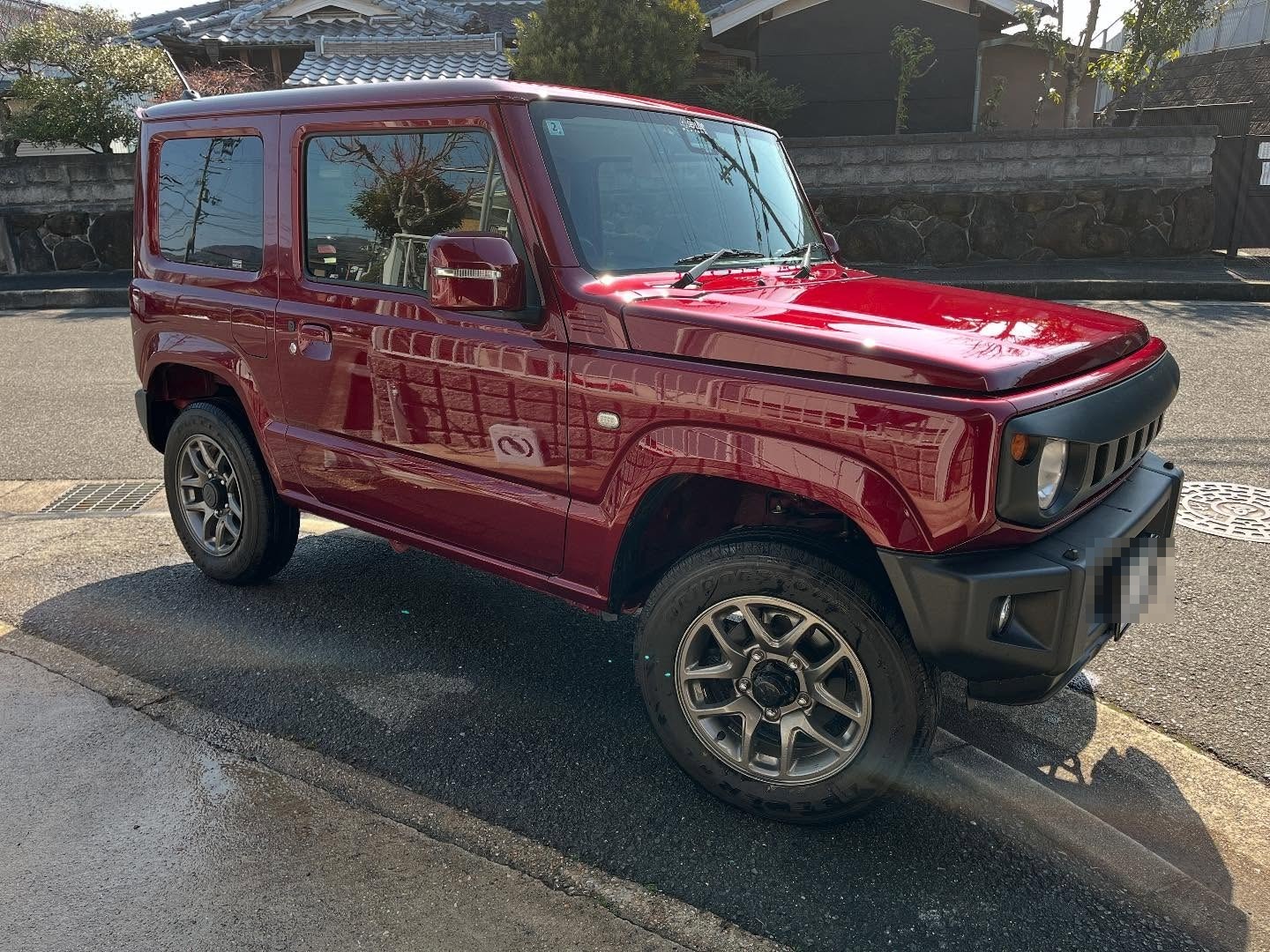 赤いスズキ・ジムニーJB64。洗車直後で塗装が濡れて光っている