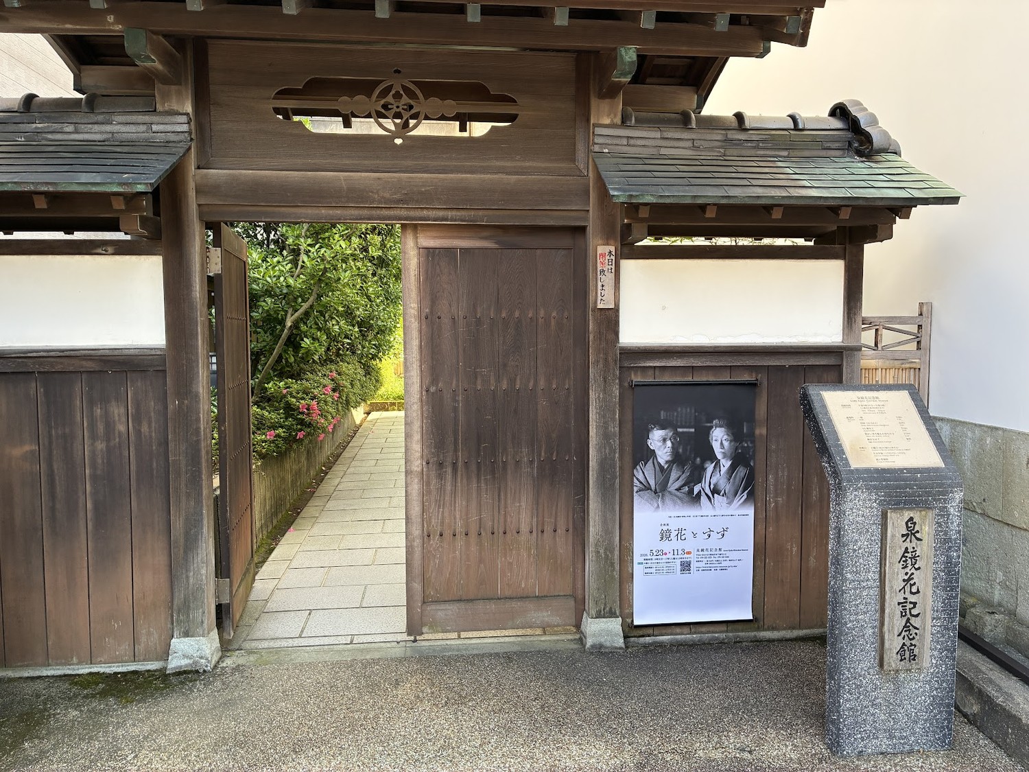 泉鏡花記念館の門。企画展「鏡花とすず」のポスターが掛かっている