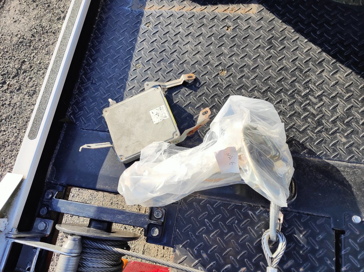 積載車の荷台に置かれたNAロードスターのECUと、錆びた取り付けステー
